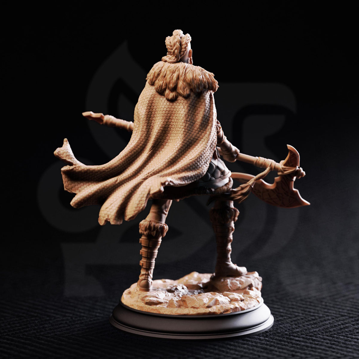 A figurine of a warrior figure with a flowing cape and wielding a sword, standing on a base against a dark background.