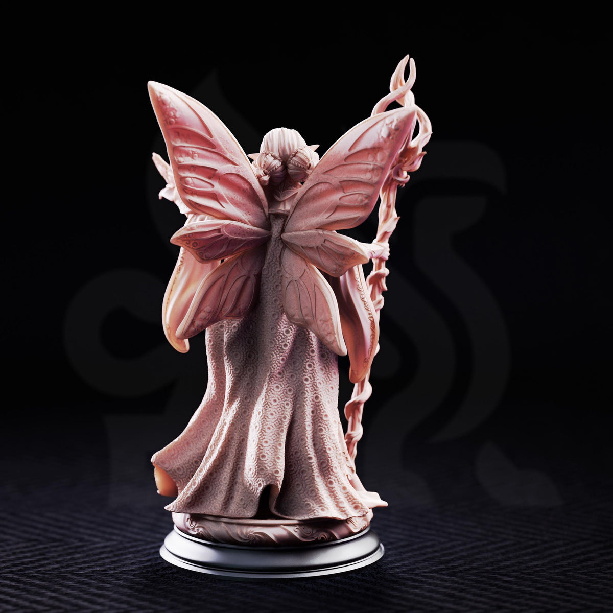 A figurine of a fairy with butterfly wings, standing on a base and holding a staff.