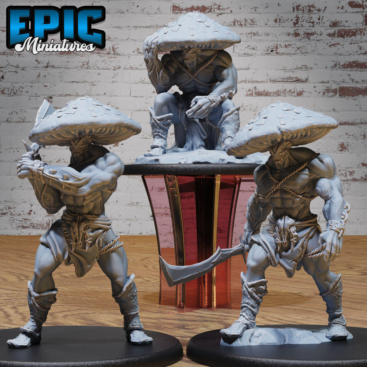 three figurines of mushroom-like creatures, each with unique poses and weapons, displayed on a wooden surface against a brick wall background.