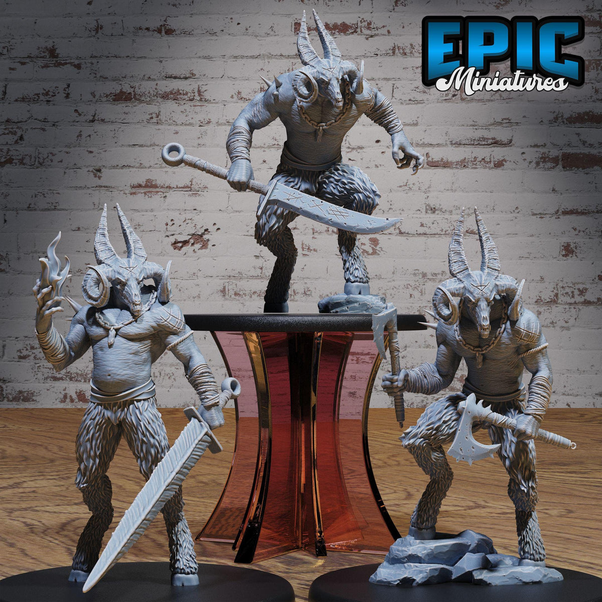 three detailed figurines of fantastical creatures, including a large horned figure, a winged figure, and a creature with sharp teeth and claws. The figurines are posed in various dynamic stances, with one standing on its hind legs and the others holding weapons. The background is a brick wall, which provides a stark contrast to the intricate details of the figurines.