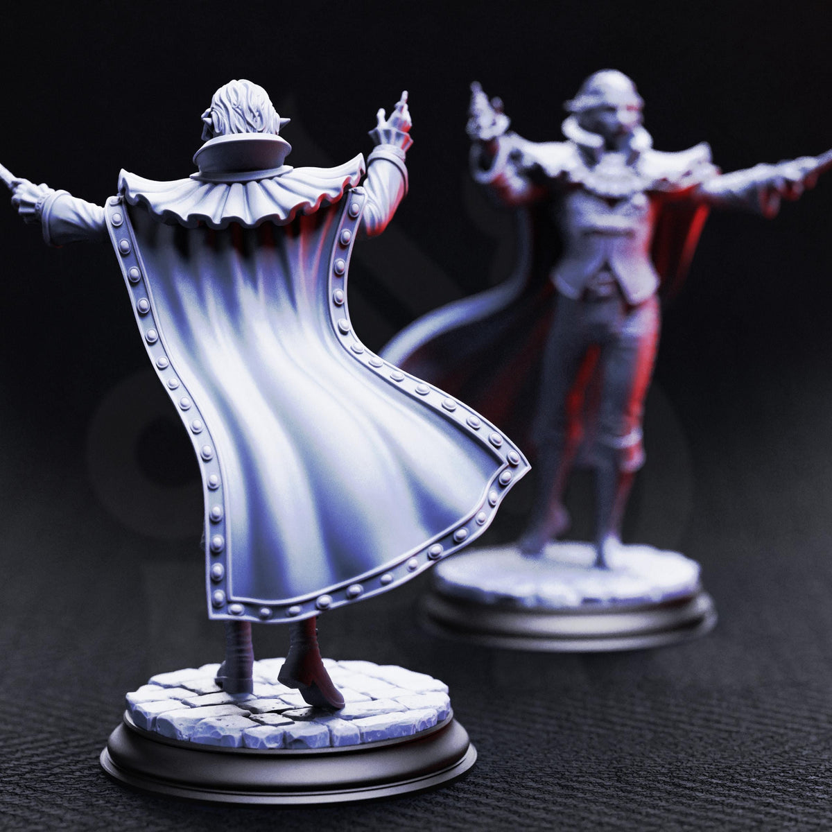 two figurines of a person in a cape, one standing and one sitting, against a dark background.
