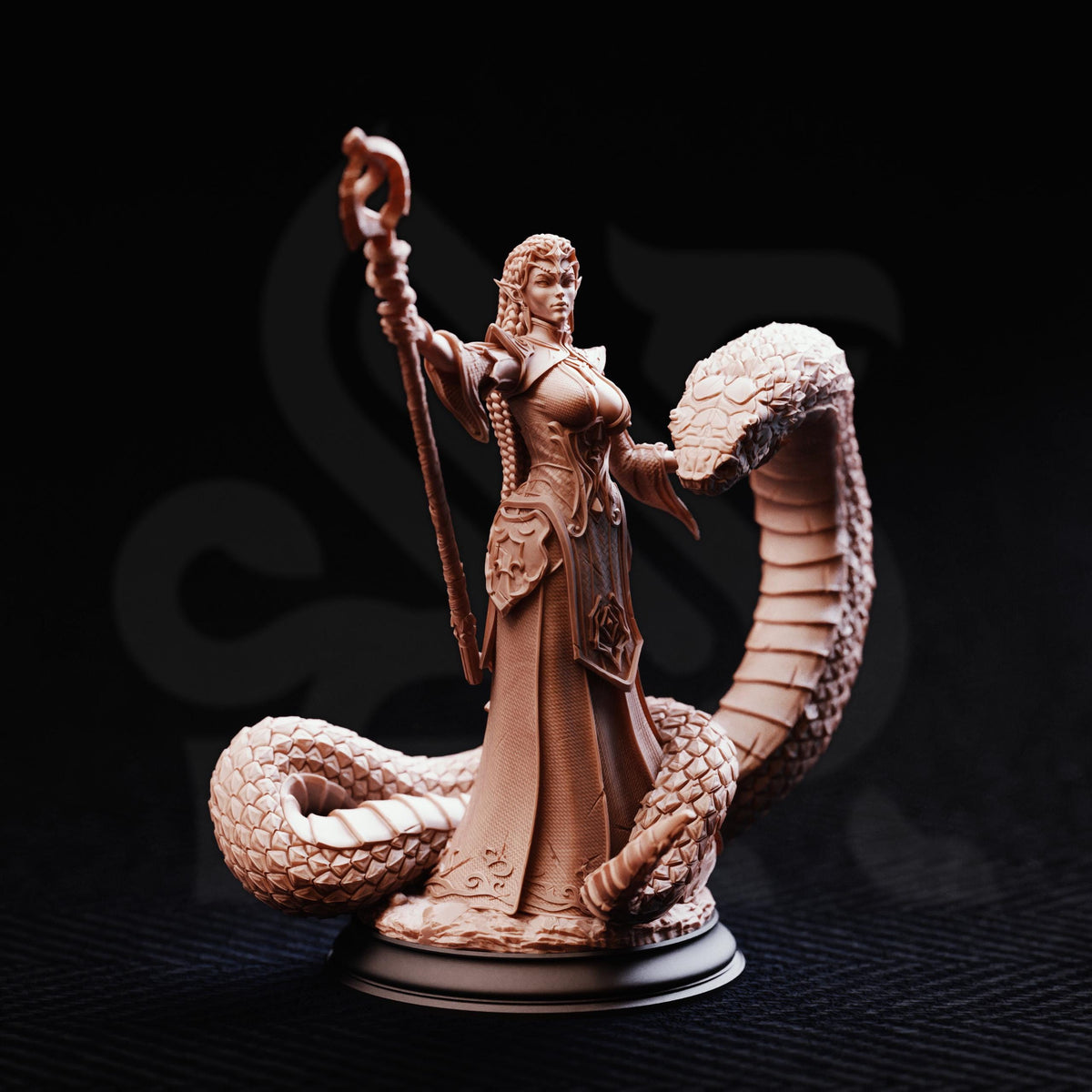 A detailed figurine of a woman with a staff and a snake, set against a dark background.