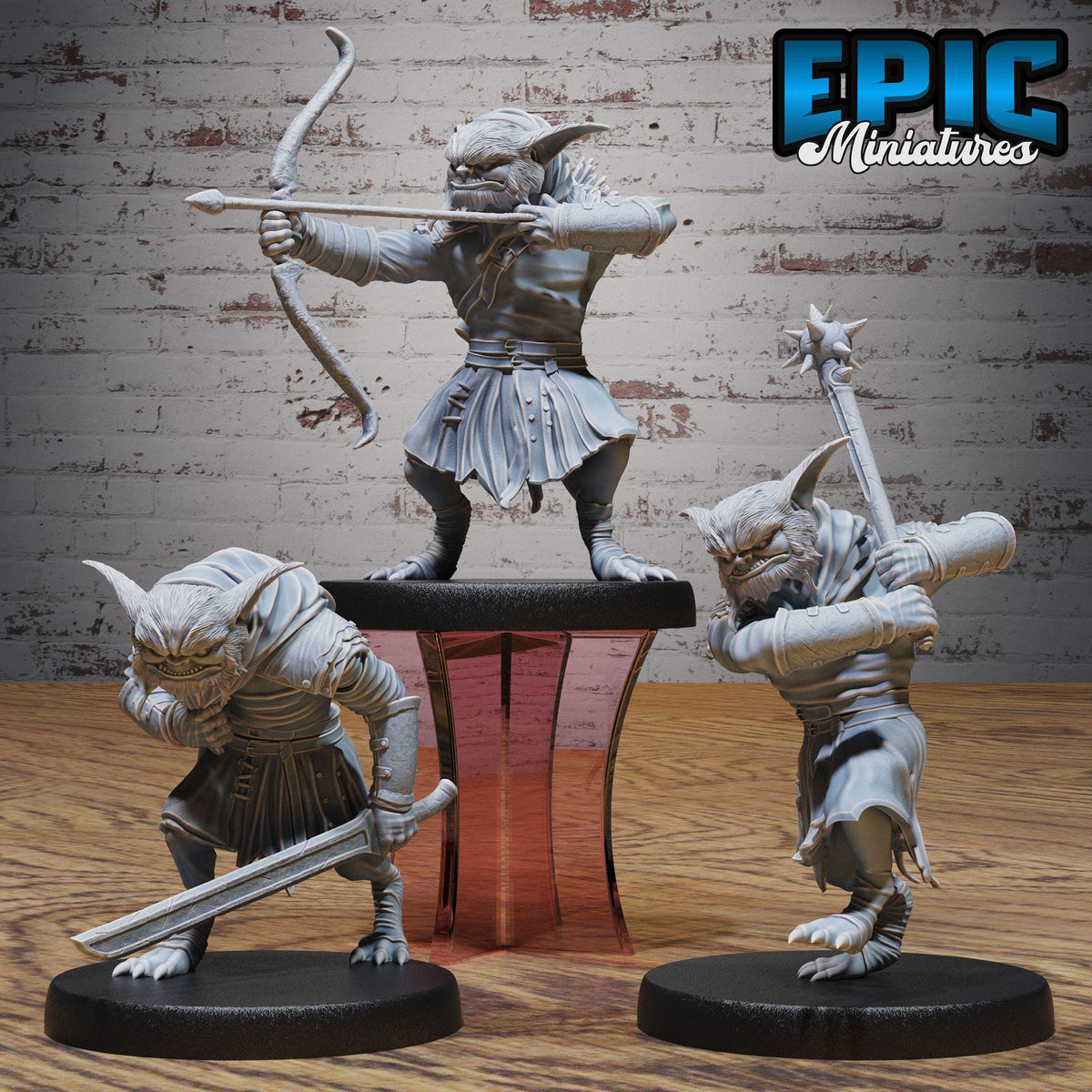 three figurines of fantastical creatures, each holding a weapon and standing on a platform.