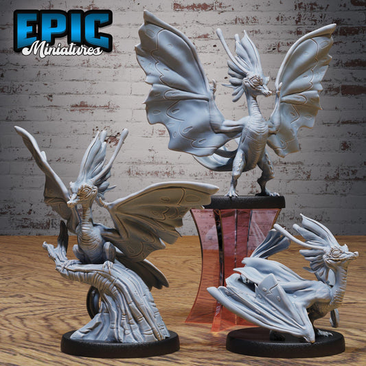three detailed sculptures of fantastical creatures, including winged, winged, and winged dragon-like figures, set against a brick wall backdrop.