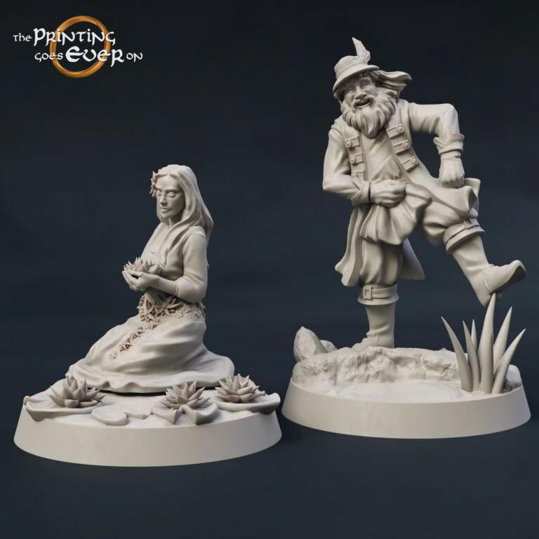 two figurines, one of a woman sitting and the other of a man dancing, both on a base with flowers and plants.