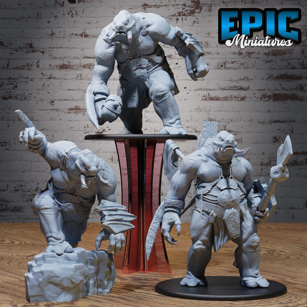 three figurines of fantastical creatures, likely from a fantasy or science fiction setting. The figurines are displayed on a wooden surface, with a brick wall in the background.