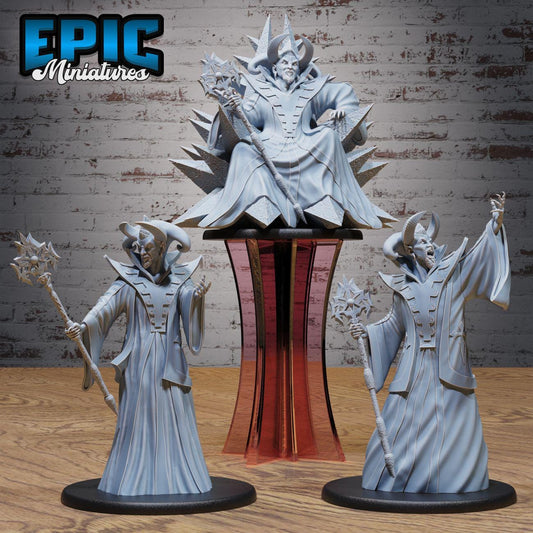 three miniature statues of characters, including a central figure seated on a pedestal and two smaller figures standing nearby. The statues are set against a brick wall background, creating a visually striking scene.