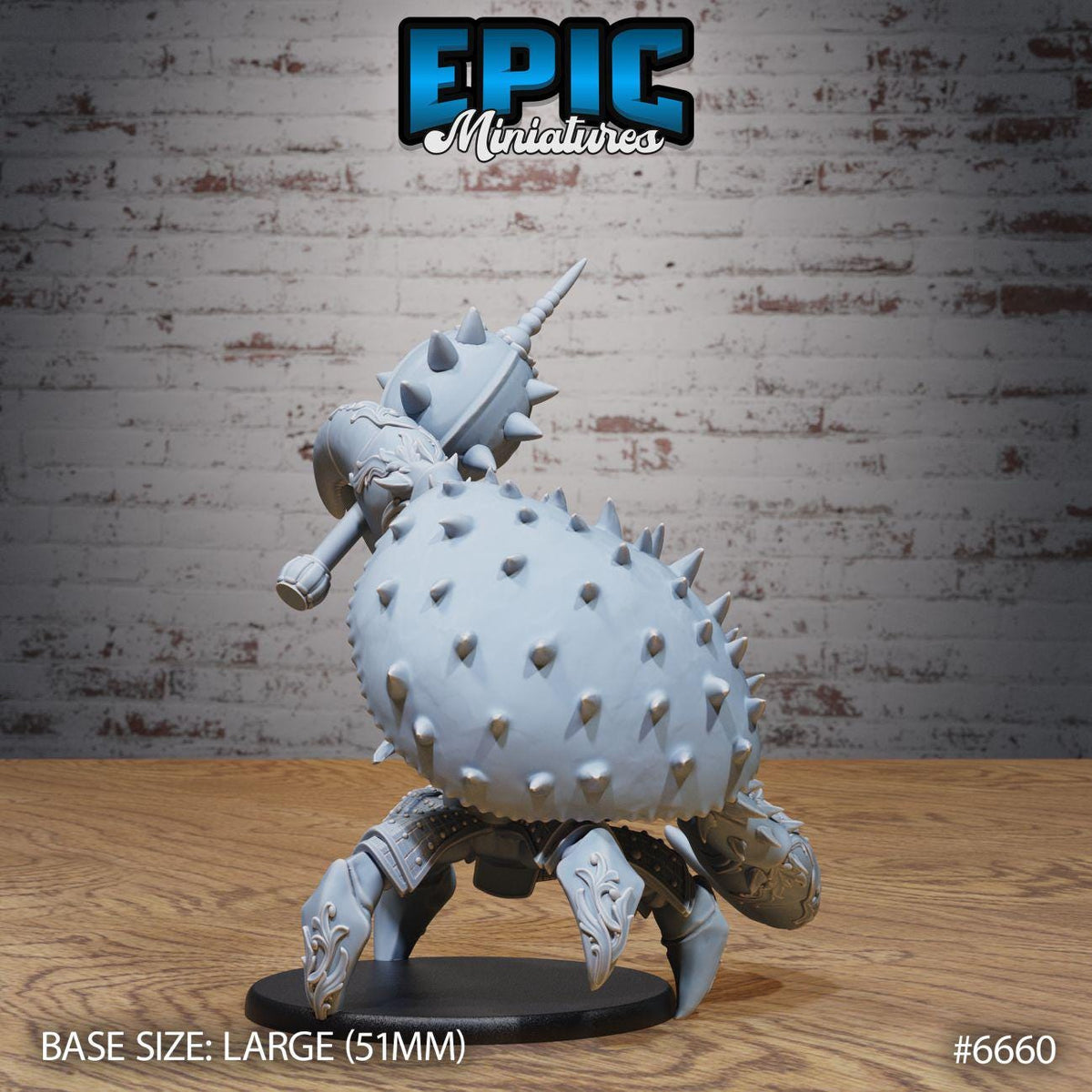 A large model of a crab-like creature with spikes on its back, sitting on a wooden surface against a brick wall background.