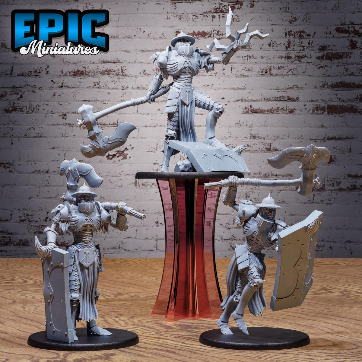 three miniature figures of knights, each holding various weapons such as swords, shields, and spears, standing on a wooden surface against a brick wall background.