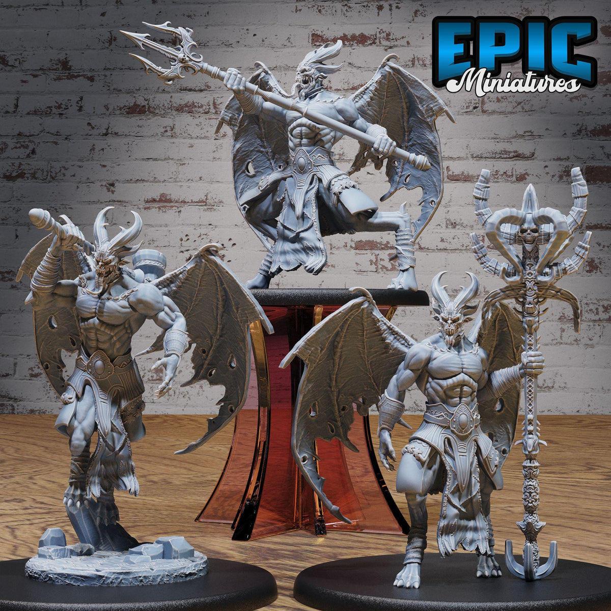 three detailed figurines of winged, winged creatures with horns and claws, standing on pedestals and holding various weapons.