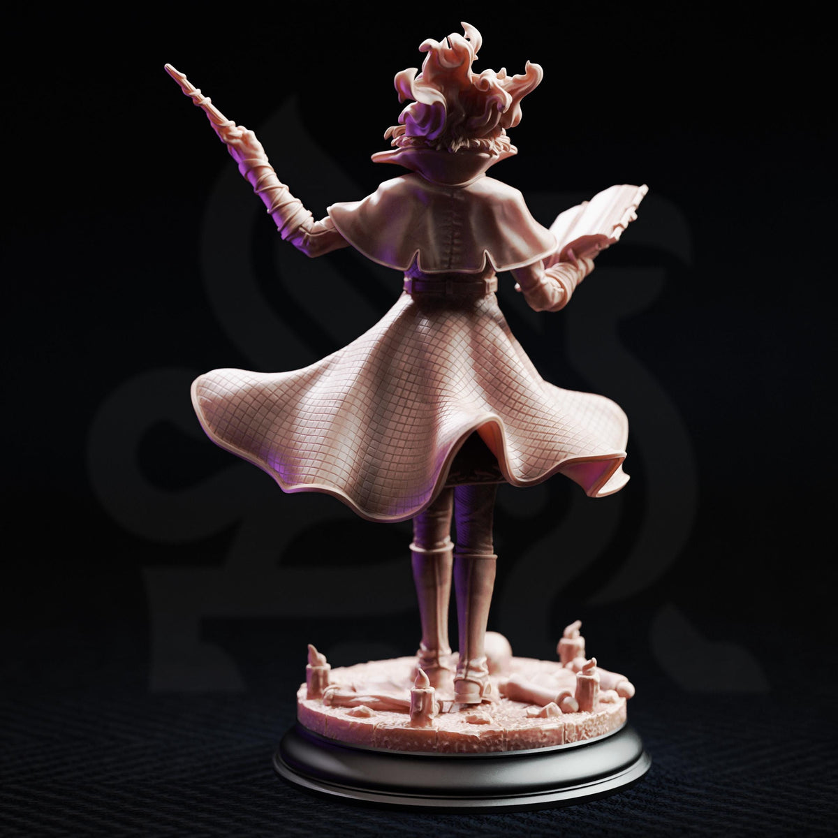 A figurine of a woman with a flowing dress and a large hat, holding a book and a staff, standing on a base with candles and other decorative elements.