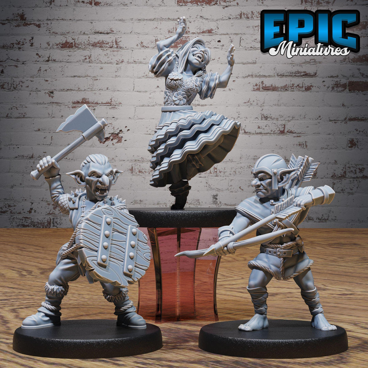 three miniature figures, including a dwarf figure with a sword, a dancing figure, and a warrior figure, all posed on a wooden surface against a brick wall background.