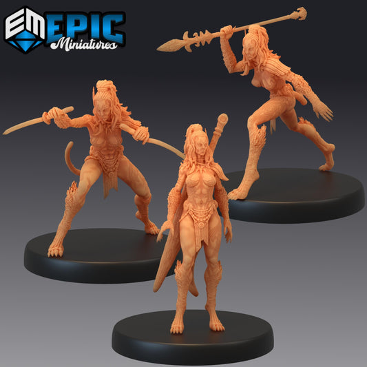 three figurines of female characters, each with unique poses and weapons, displayed on platforms.