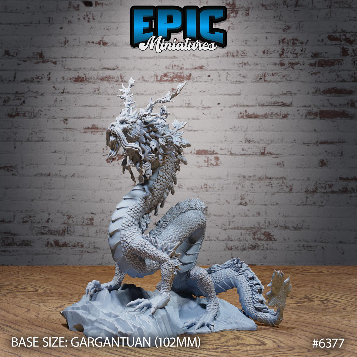 a detailed model of a dragon, specifically a gargantuan dragon, with intricate scales and a fierce expression. The dragon is positioned on a rock, and the background is a brick wall. The image is labeled with the text "EPIC Miniaturies" and "BASE SIZE: gargantuan (102mm)" indicating the scale of the model. The image also includes the number "#6377".