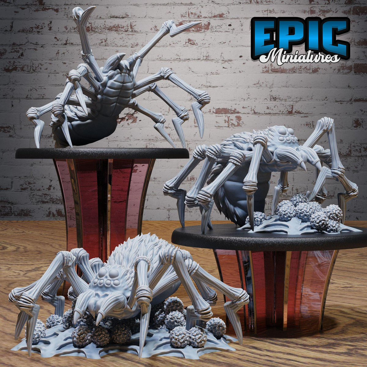 three detailed figurines of large, intricate spiders on a wooden surface.