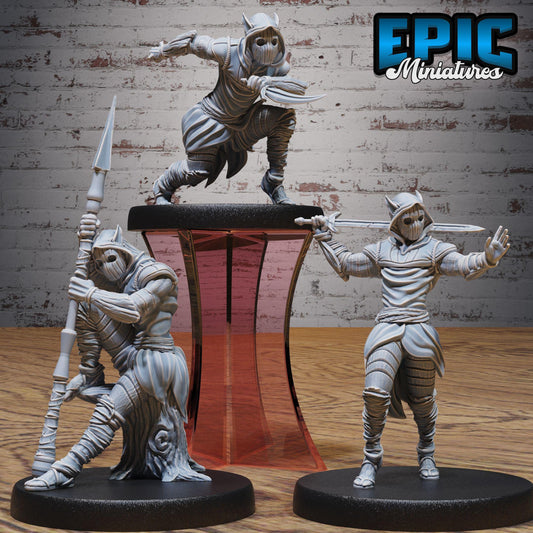 three figurines of soldiers, each holding a weapon and standing in different poses.