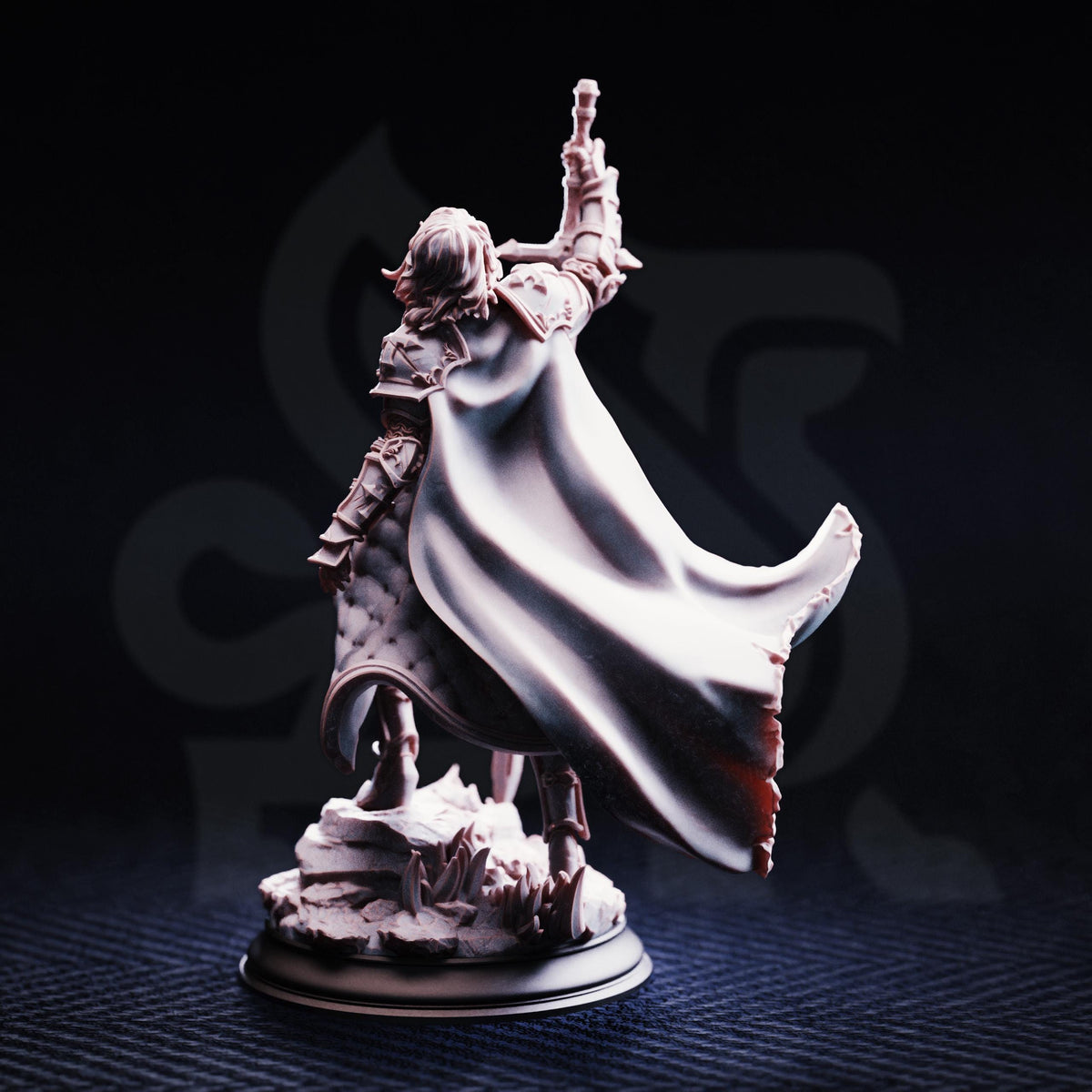 A figurine of a person with a cape and a sword raised in the air, standing on a base.