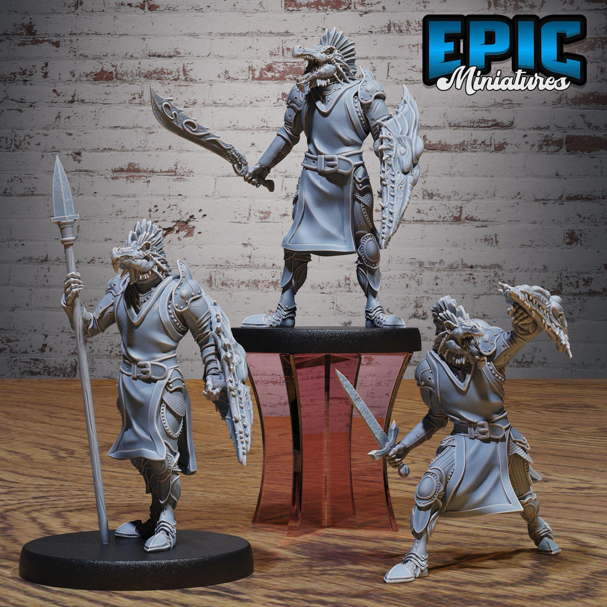 three figurines of warrior characters, each holding various weapons and standing on a platform.