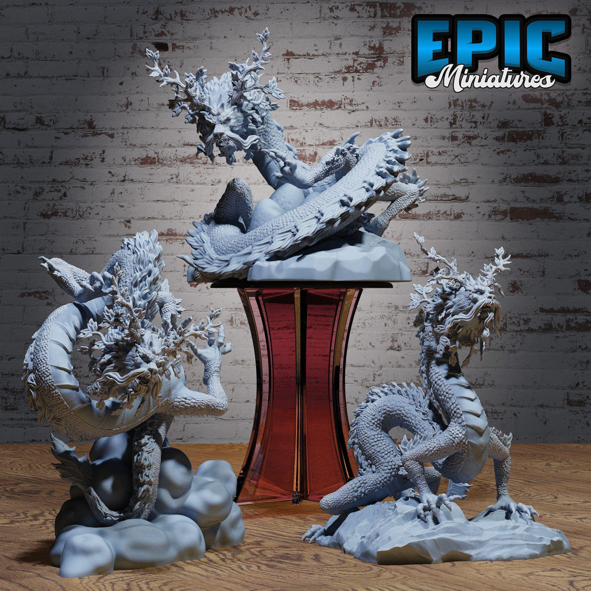 three detailed sculptures of dragons, each with unique features and poses, set against a brick wall background.