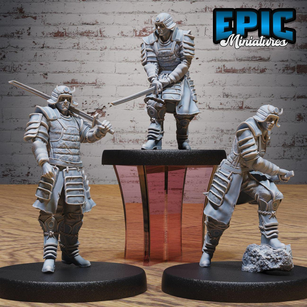 three miniature figures of Japanese samurais, each holding a sword and standing on a platform.