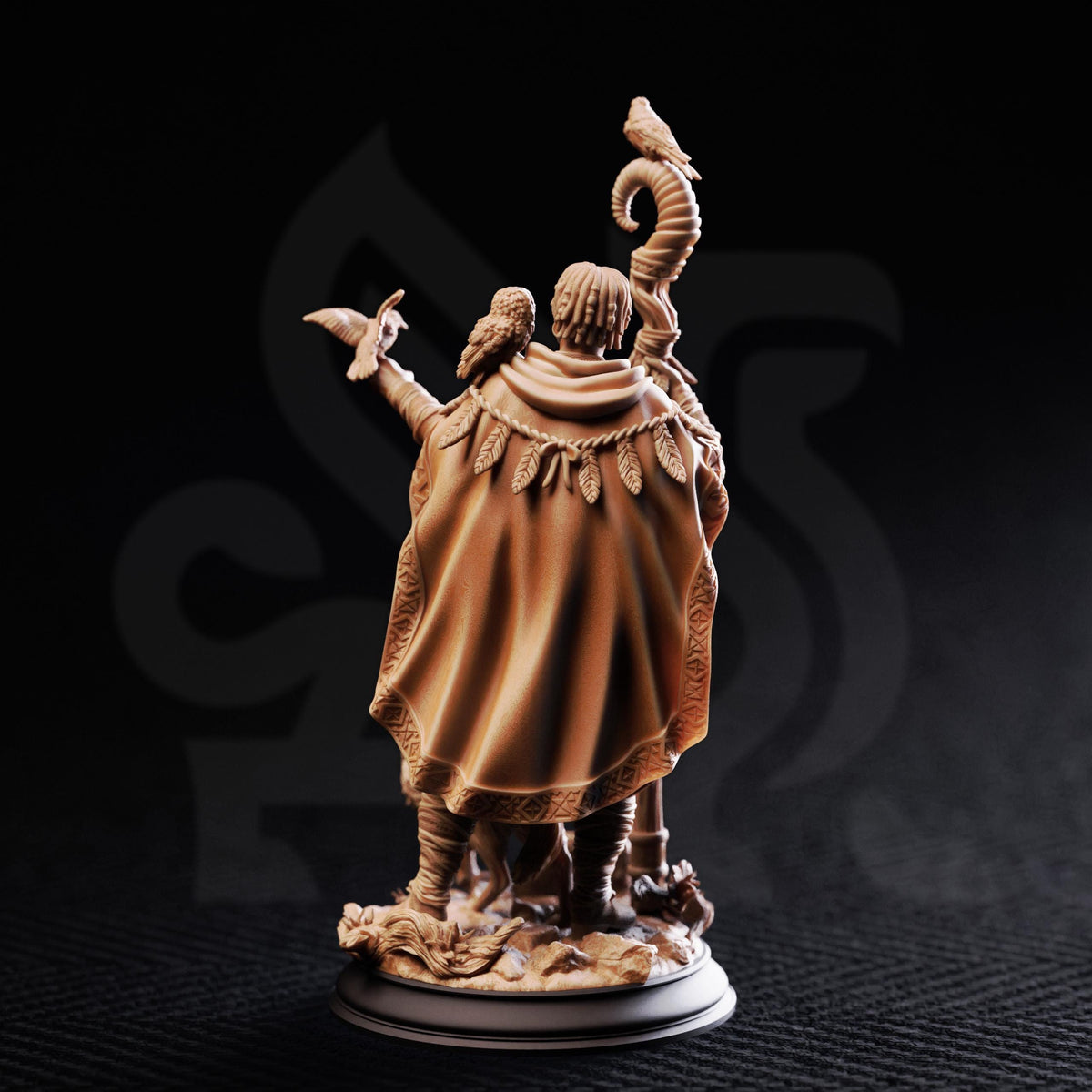A detailed figurine of a person wearing a cape and holding a staff, with birds perched on their shoulders, against a dark background.
