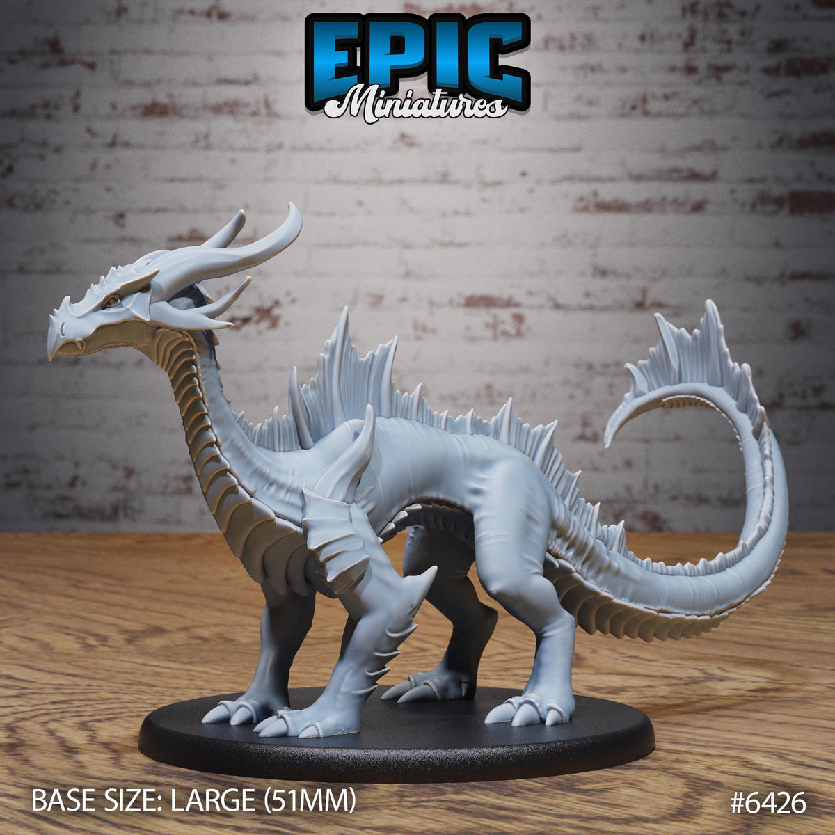 A large gray dragon figurine is displayed on a black base, with a brick wall in the background.