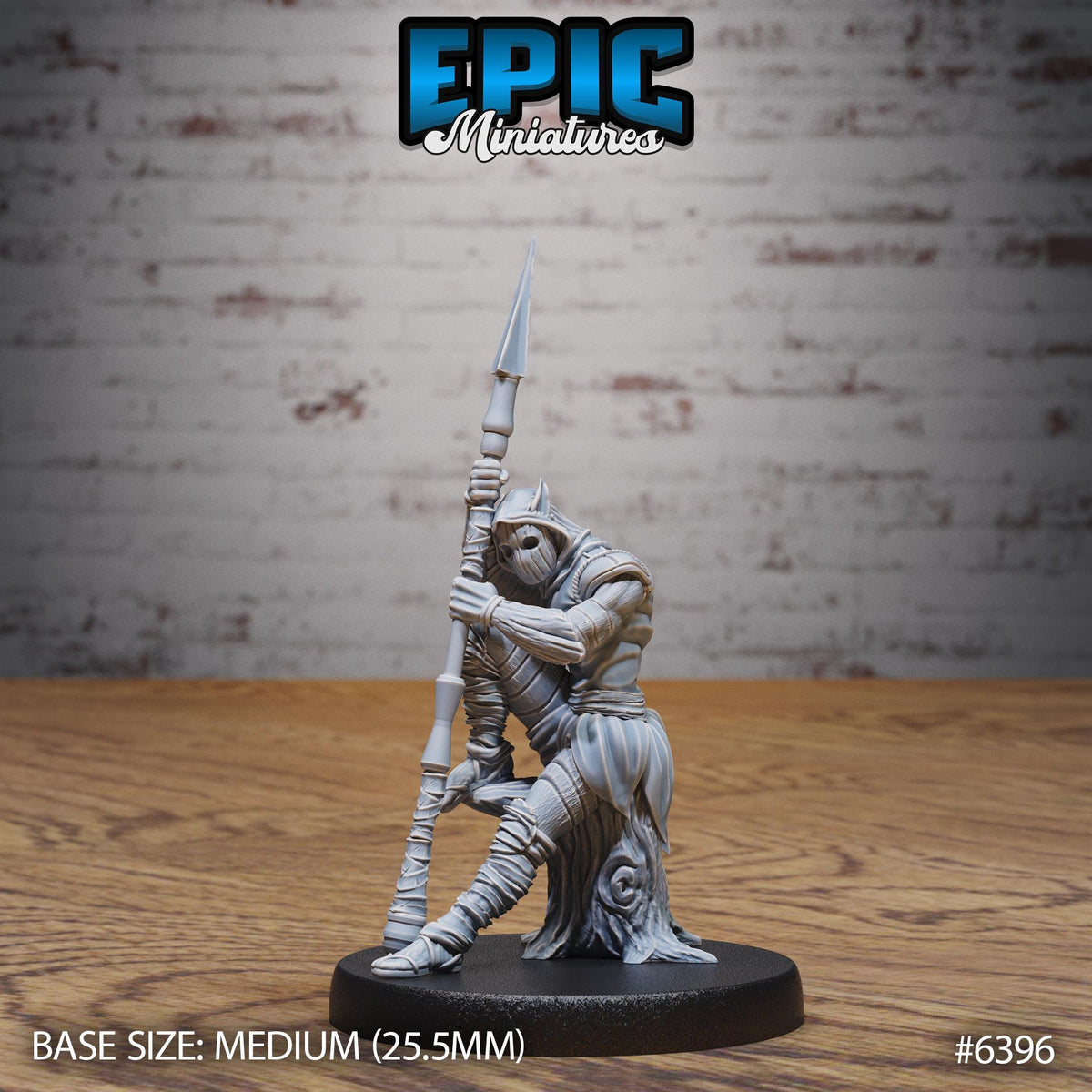 A figurine of a warrior standing on a wooden surface, holding a spear. The figurine is described as a "MEDIUM" size, which is 25.5 millimeters in height. The background is a brick wall.