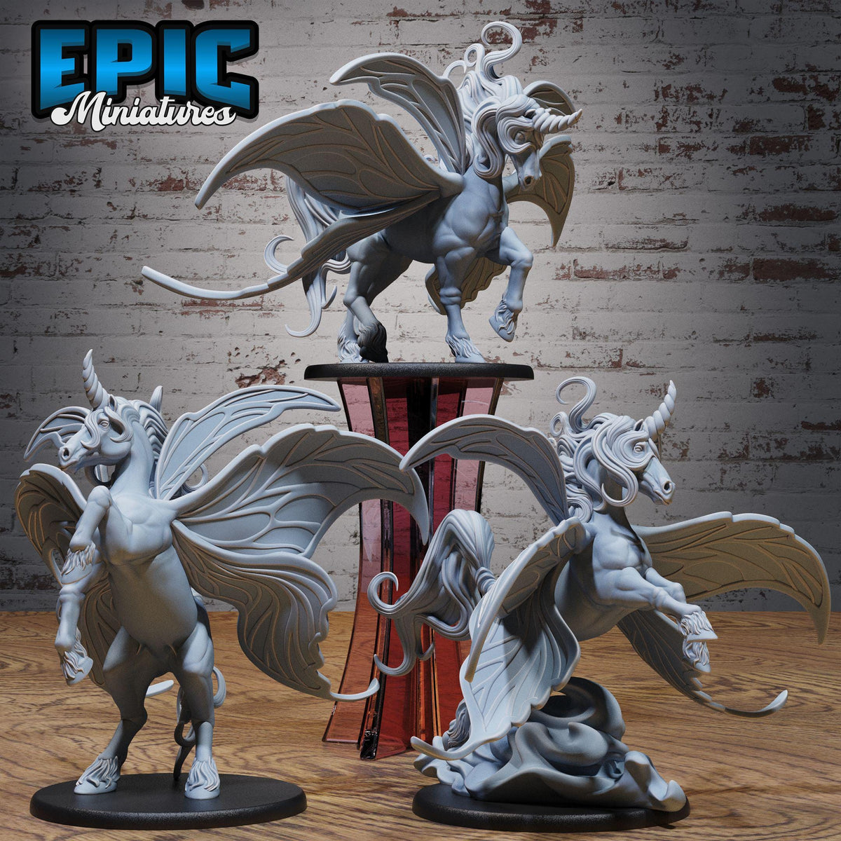 three detailed figurines of winged creatures, likely mythical or fantastical in nature, displayed on a wooden surface against a brick wall background.