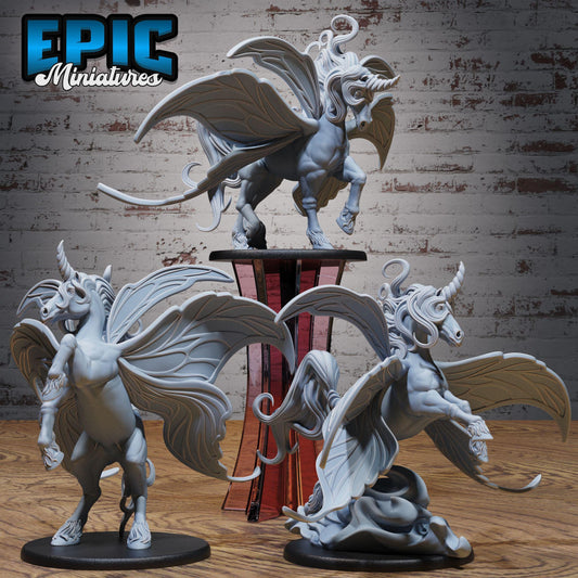 three detailed figurines of winged creatures, likely mythical or fantastical in nature, displayed on a wooden surface against a brick wall background.