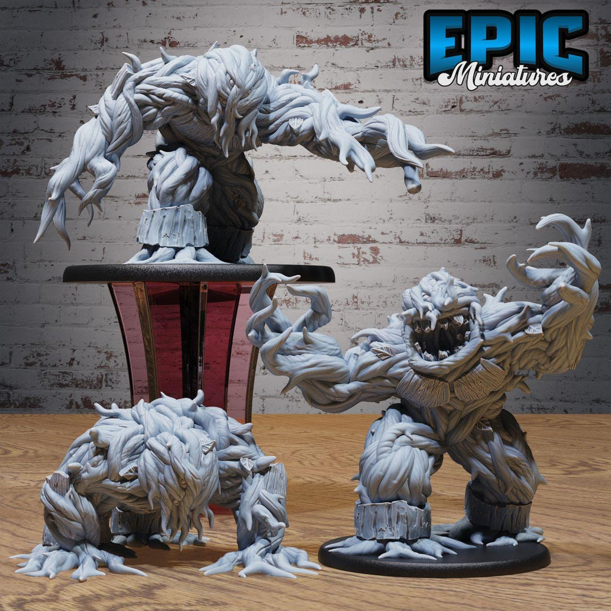 three large, detailed figurines of fantastical creatures with intricate, textured bodies and dynamic poses, set against a brick wall background.