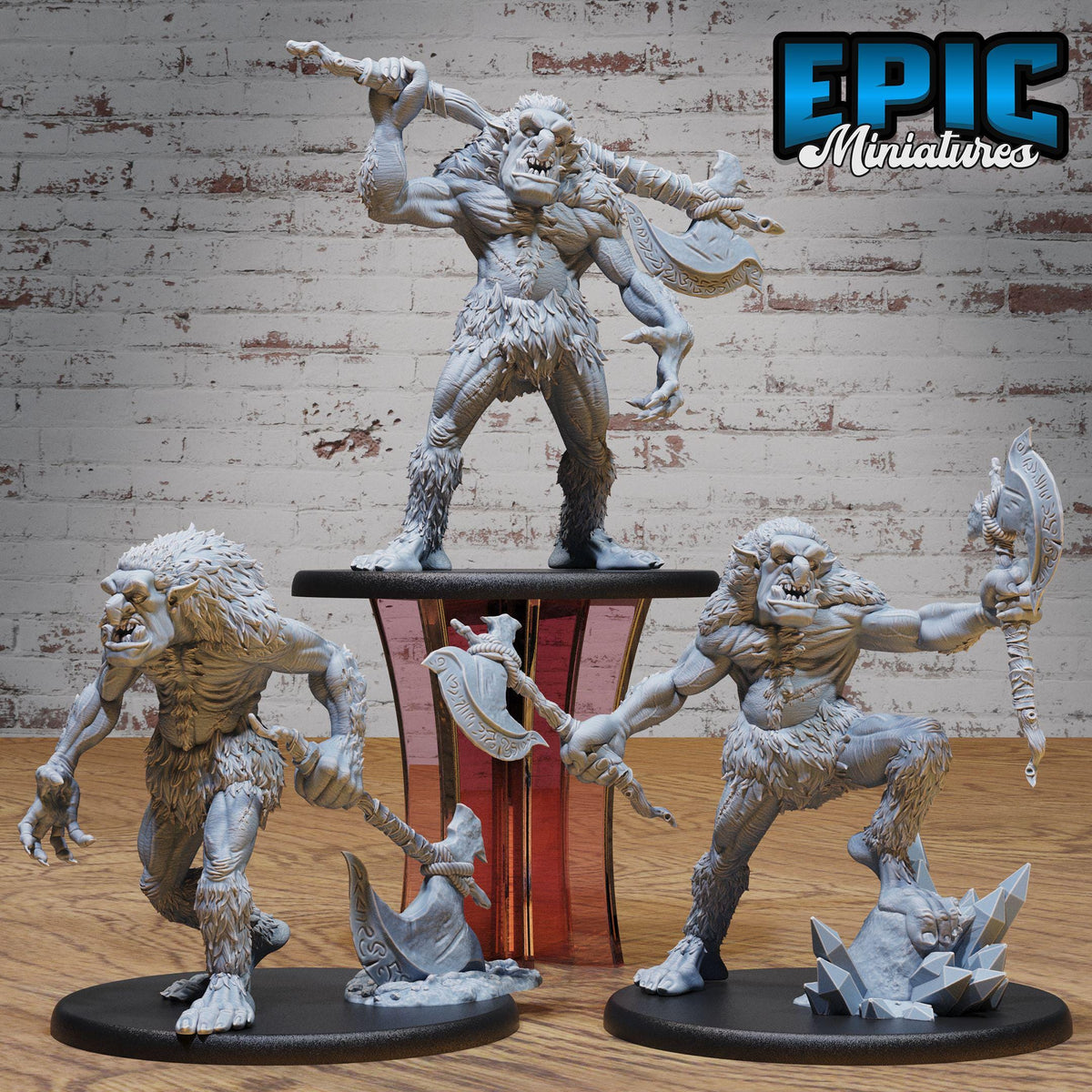 three figurines of fierce-looking creatures, possibly mythical or fantasy-inspired, displayed on a wooden surface against a brick wall background.