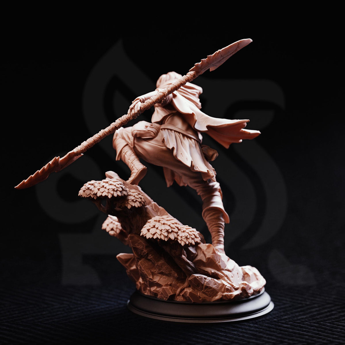 A detailed sculpture of a warrior figure holding a spear and standing on a rocky outcrop against a dark background.