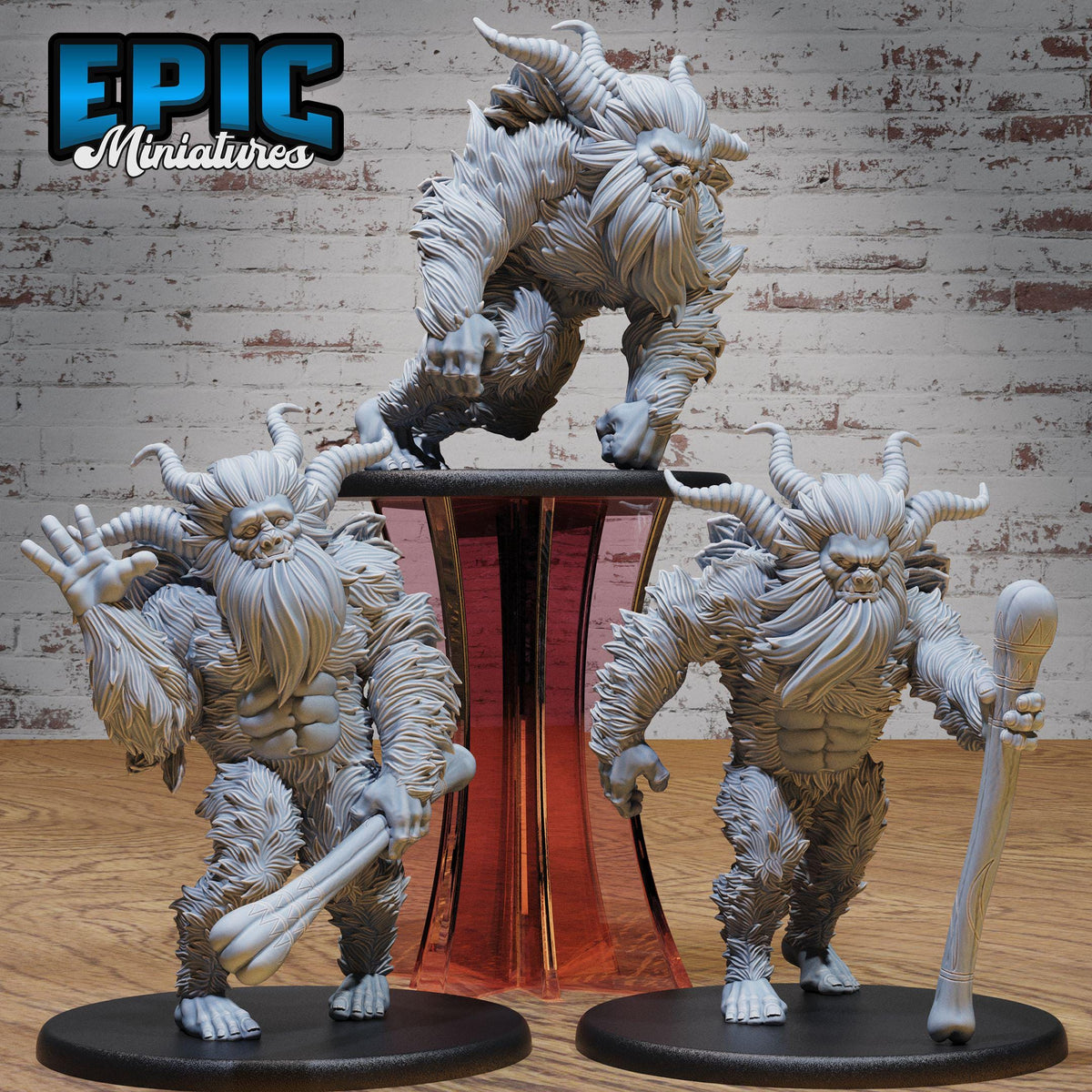 three detailed figurines of fantastical creatures, including a large horned creature, a creature with a long beard, and another creature with a long horned head. The figurines are displayed on a stand, and the background is a brick wall.