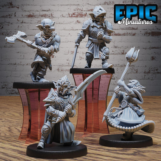 three figurines of fantasy characters, each holding different weapons, displayed on stands against a brick wall background.